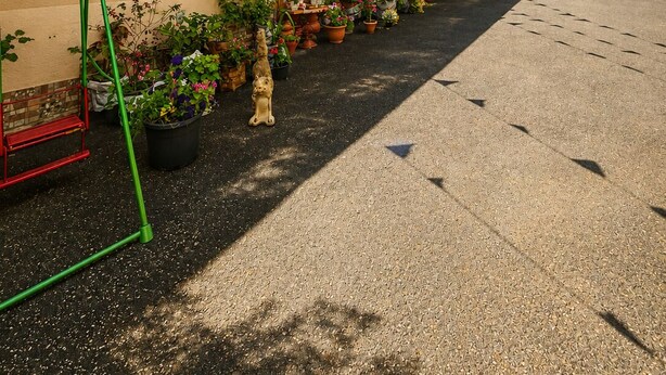 Une cour intérieure agrémentée de plantes en pot et d’un petit espace jardin.
