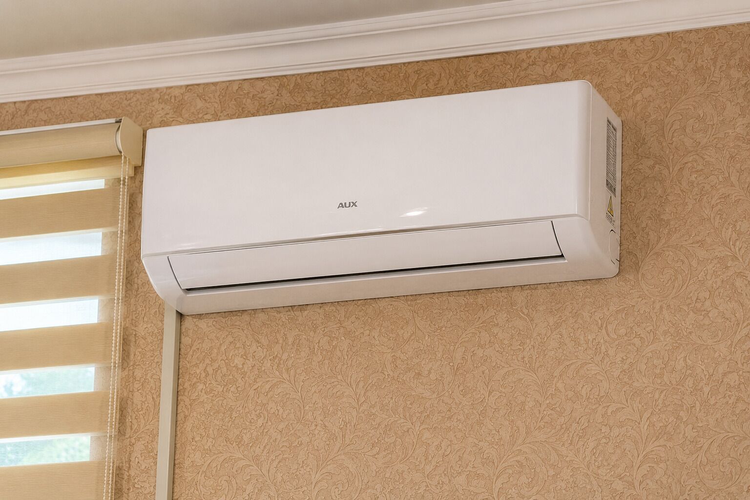 A white wall-mounted air conditioning unit labeled 'AUX' on a textured beige wall.