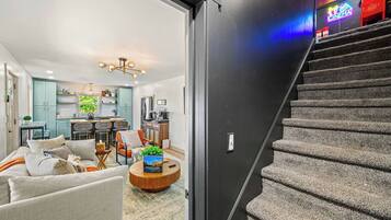 A modern living room with a sofa, coffee table, and a staircase leading to a cinema.