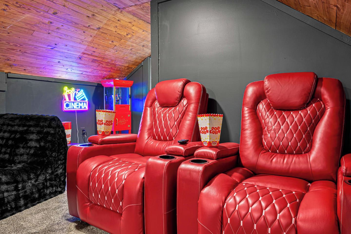 Ein kino-inspiriertes Zimmer mit roten Ledersesseln und einer Neonreklame.