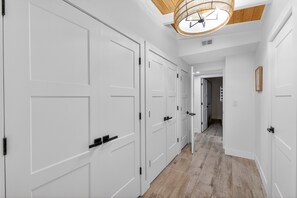 A hallway with white doors and a wooden floor. - Waterfront Home with Pool and Hot Tub  (Sarasota)