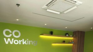 A conference room with a green wall, a long table, and four chairs. - MODERNA APARTA-SUITE CON VISTA AL LAGO (cartagena)
