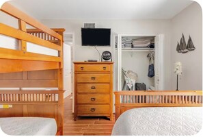 A bedroom with a bunk bed, a dresser, a television, and a closet. - Little Bit of Paradise, Direct Beachfront, Stunning Sunsets, Sleeps 6 (Clearwater)