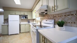 Cocina moderna con refrigerador, microondas, estufa y lavaplatos.