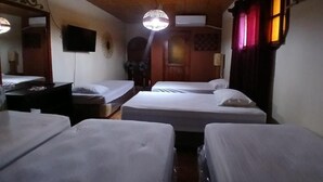 A hotel room with wooden ceiling, four beds, a TV, and a chandelier. - Hostal Don Miguel (Rivas)