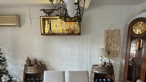 Et spiseområde med et sort bord, hvide bordpladser med et mønster og en frugtdekoration i midten.