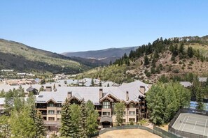 A resort with multiple buildings, a tennis court, and a mountainous backdrop. - Ski-in ski-out Beaver Creek W/pool and hot tub (Beaver Creek)