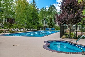 A swimming pool with lounge chairs, a hot tub, and a surrounding garden. - Ski-in ski-out Beaver Creek W/pool and hot tub (Beaver Creek)
