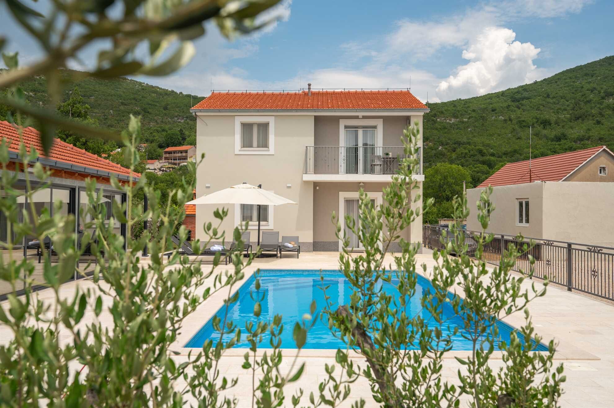 A two-story building with a swimming pool in the foreground.