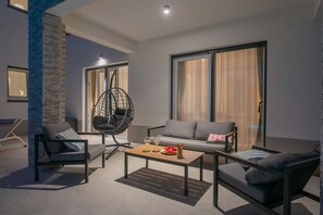 A modern living room with a hanging chair, sofa, and coffee table. - Villa Ginger | Modern Villa with Private Pool (Tugare)