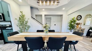 A dining area with a wooden table, black chairs, and a patterned rug. - Entire Downtown Home - Yellowstone and Teton Base (Idaho Falls)
