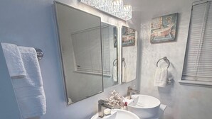 Ein Badezimmer mit zwei Waschbecken, einem großen Spiegel und einem Handtuchhalter.
