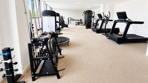 Et fitnesscenter med forskellig træningsudstyr, herunder løbebånd og styrkemaskiner.