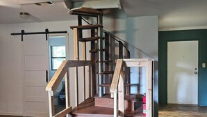 A staircase with wooden steps and metal railings, leading to a landing.