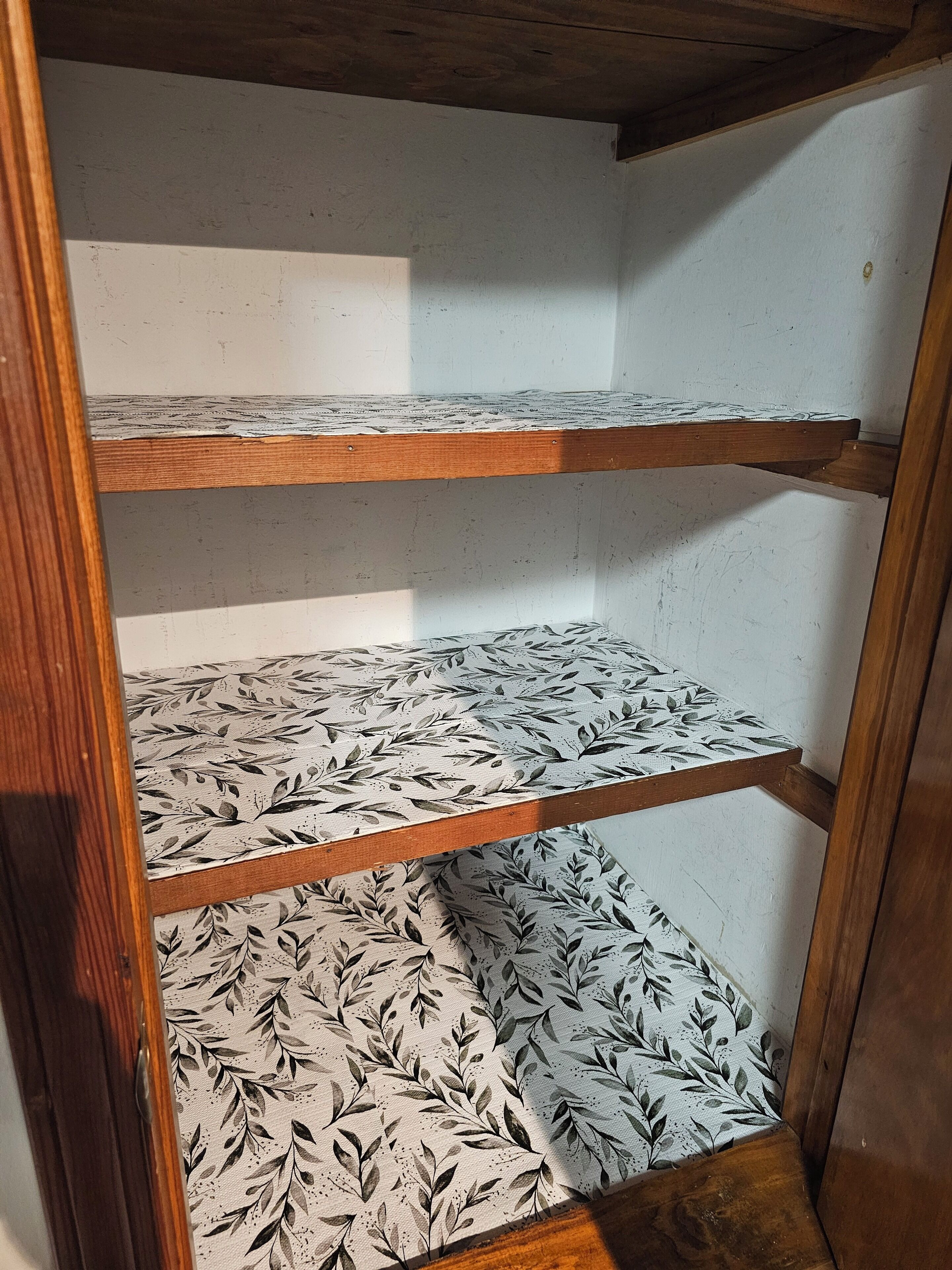 Une étagère en bois recouverte d’un tissu à motifs.