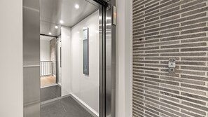 A modern elevator with a glass door and a wall-mounted control panel. - The Avenue ~ Sawtell Village Prime Location (Sawtell)