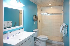 Ein Badezimmer mit weißem Waschbecken, WC und Dusche.