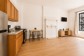 Eine moderne Küche mit Holzschränken, einer Granit-Arbeitsplatte, einem eingebauten Herd und einem Essbereich mit Tisch und Stühlen.