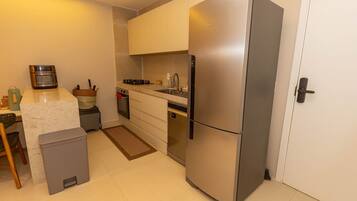 A modern kitchen with a stainless steel refrigerator, a built-in oven, and a sink.