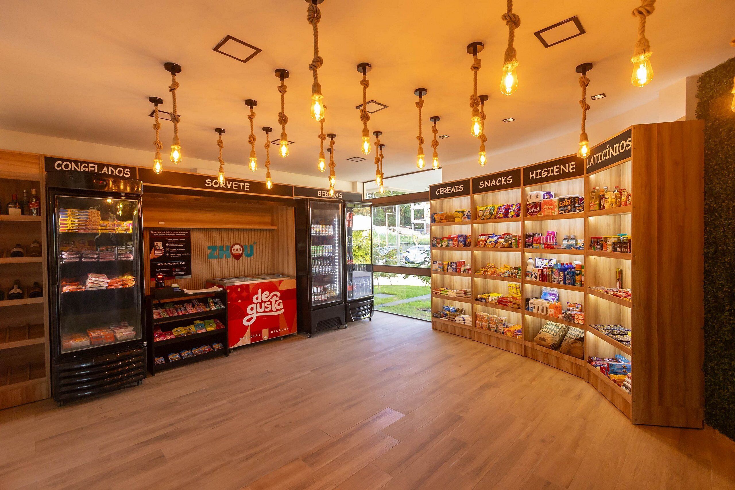 Un magasin avec des étagères remplies d’en-cas, de céréales et de boissons, ainsi qu’un rayon réfrigéré pour les boissons.