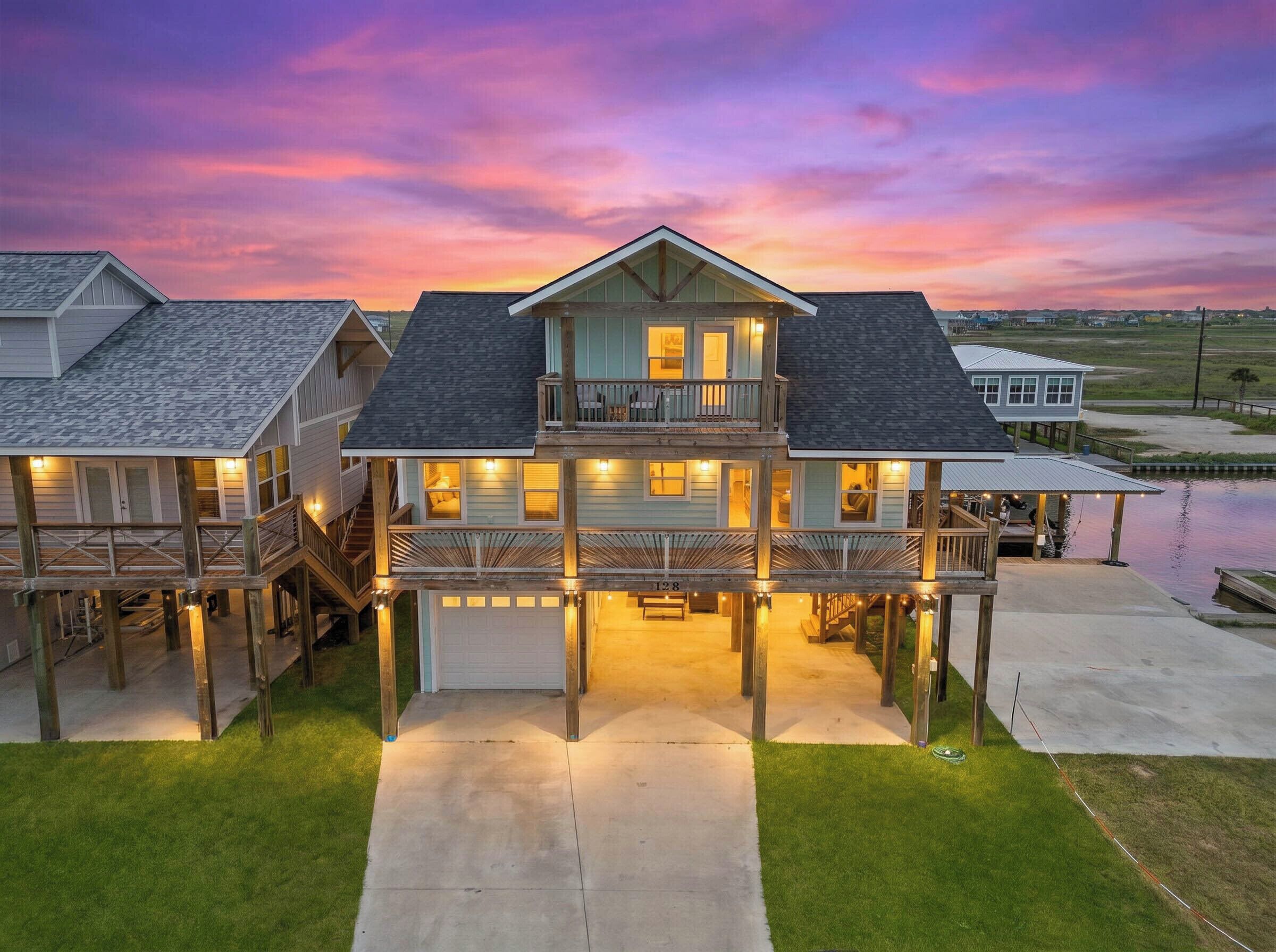A waterfront house with a covered dock, multiple decks, and a garage.