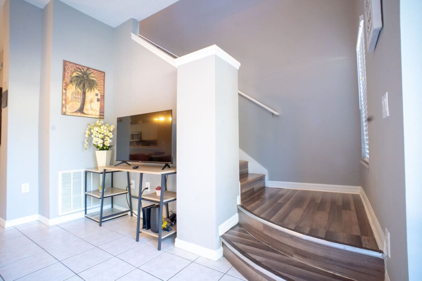 A modern interior with a staircase, a dining area with a table and chairs, and a kitchen area.