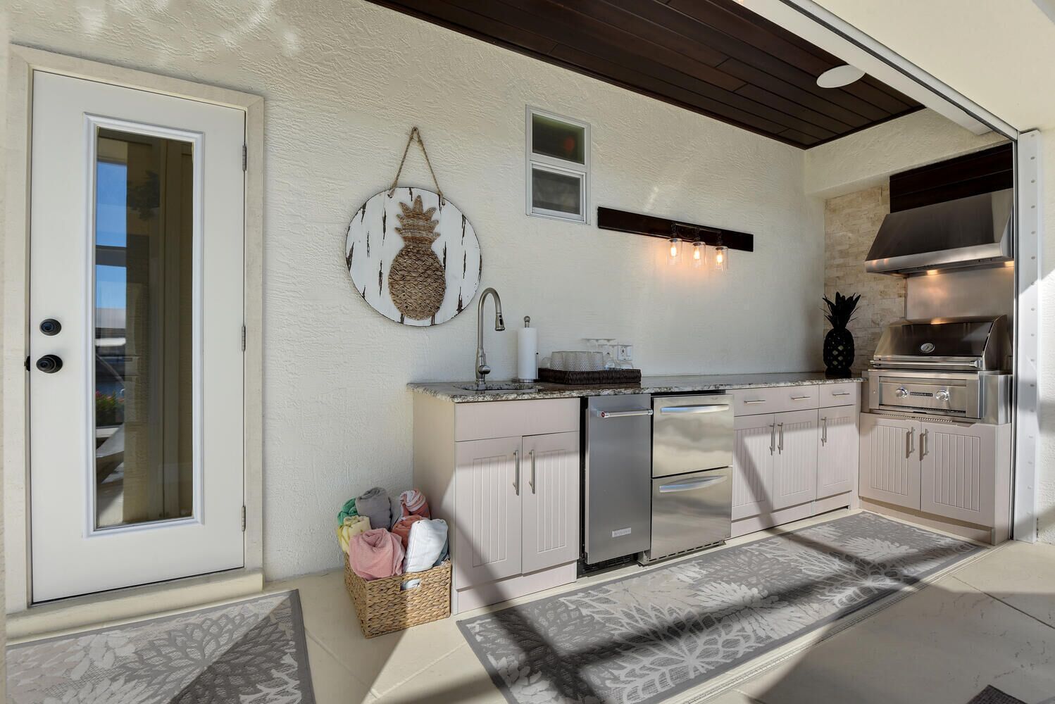 A kitchen with a built-in oven, a refrigerator, and a sink.
