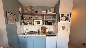 Une cuisine compacte équipée d’un four à micro-ondes, d’un évier et d’un petit réfrigérateur.