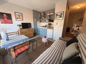 A compact living space with a kitchenette, a dining area, and a seating area with a sofa and a chair. - Studio flat + balcony, 150 metres from the Beach (ARCACHON)