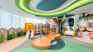 A children's play area with a slide, climbing structures, and a wooden bench. - Studio Minimalist Areum Residence At Antasari Place (Jakarta)