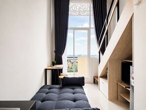 Un dormitorio moderno con cama, escritorio y vistas a la ciudad.