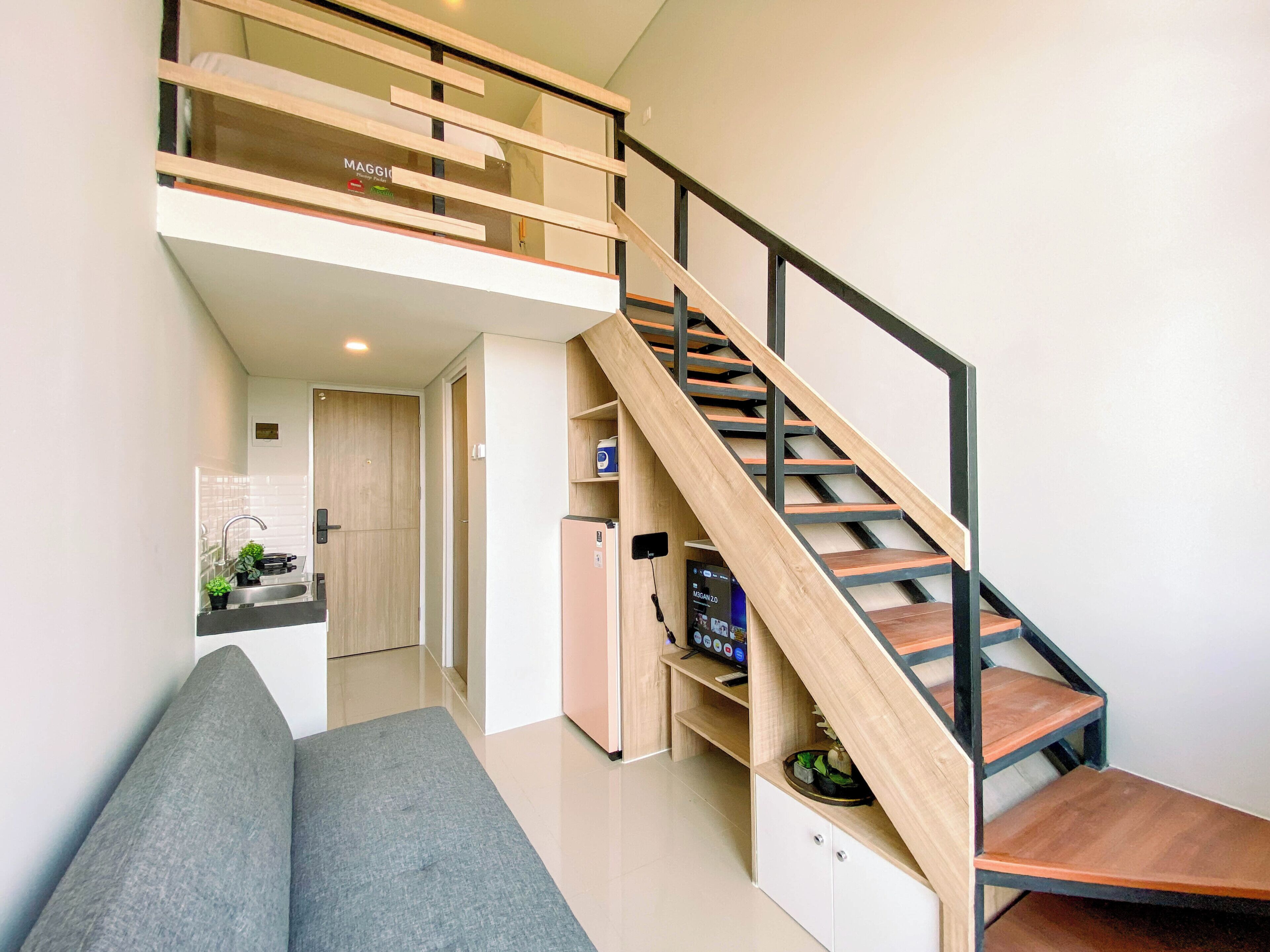 A modern interior with a staircase, a kitchen area, and a seating area.