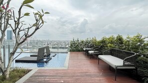 A rooftop pool area with lounge chairs and a view of the cityscape. - Cozy Studio With City View Apartment At B Residence Grogol (Jakarta)
