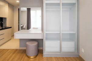 Un baño moderno con tocador, espejo y vestidor.