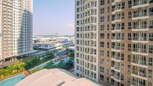 A high-rise residential building with multiple balconies, a swimming pool, and a landscaped area. - Studio Polished Areum Residence At Tokyo Riverside (Jakarta)