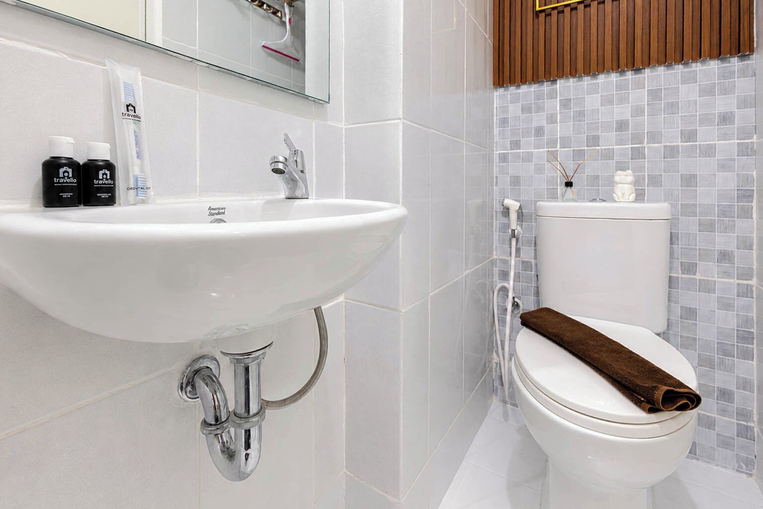 A bathroom with a white sink, a toilet, and a mirror above the sink.