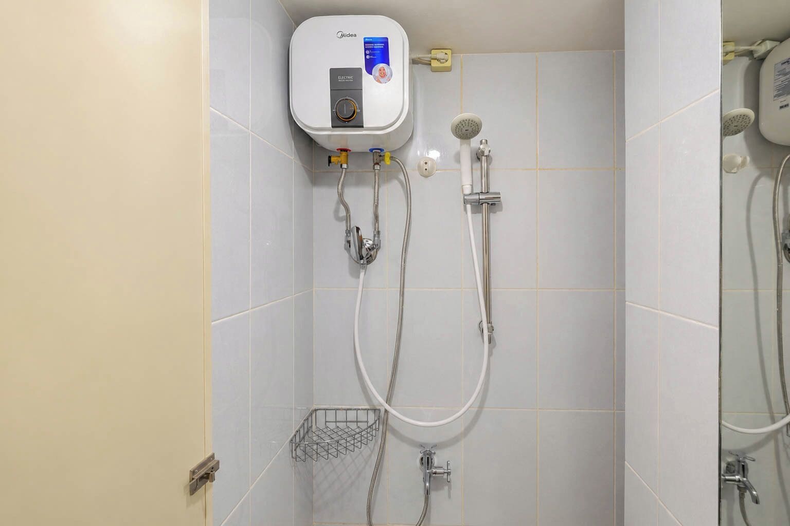 Casa de banho com esquentador, chuveiro e duche manual.
