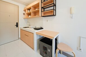 A compact kitchen with a sink, countertop, and a built-in dishwasher. - Studio Apartment Near Nice At Tokyo Riverside Pik 2 (Jakarta)