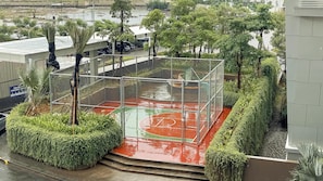 A basketball court surrounded by a metal fence, with steps leading up to it. - Studio Apartment Near Nice At Tokyo Riverside Pik 2 (Jakarta)