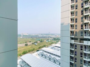 A high-rise building with multiple balconies and a view of a cityscape in the background. - Stylish Bright Studio Apartment Tokyo Riverside (No Kitchen) (Teluknaga)