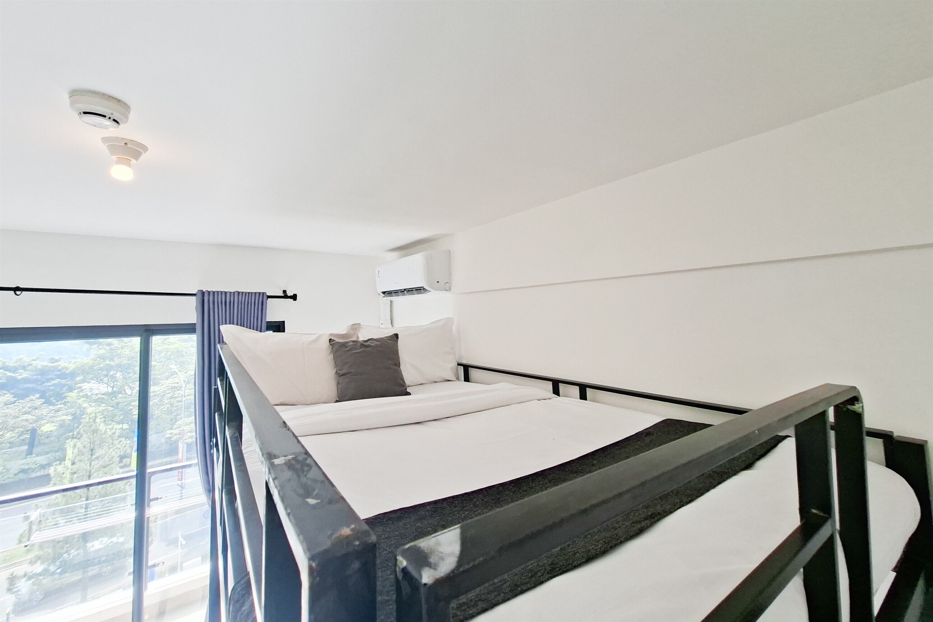A bunk bed with a view of a cityscape through a large window.