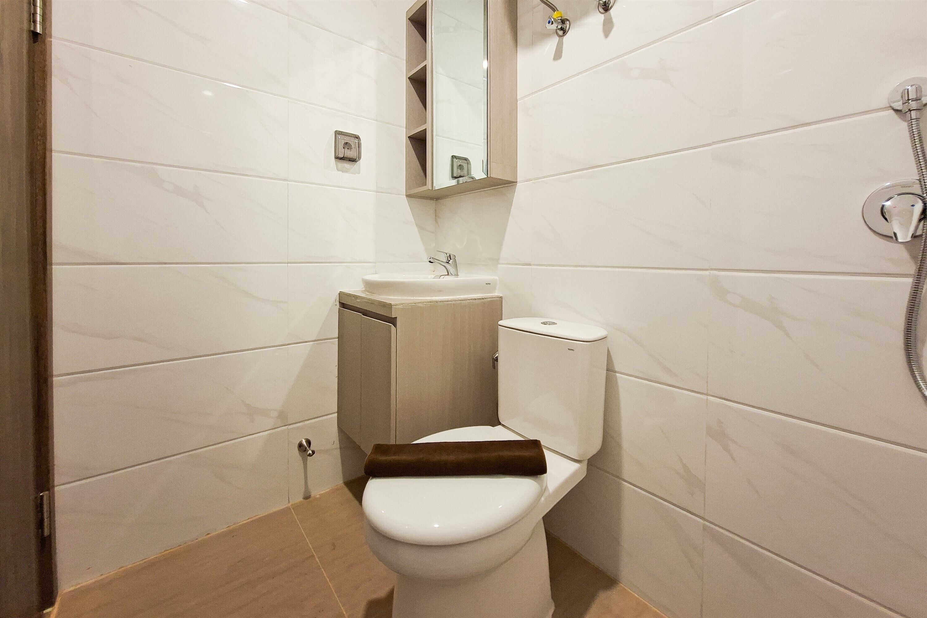 A bathroom with a toilet, sink, and shower.