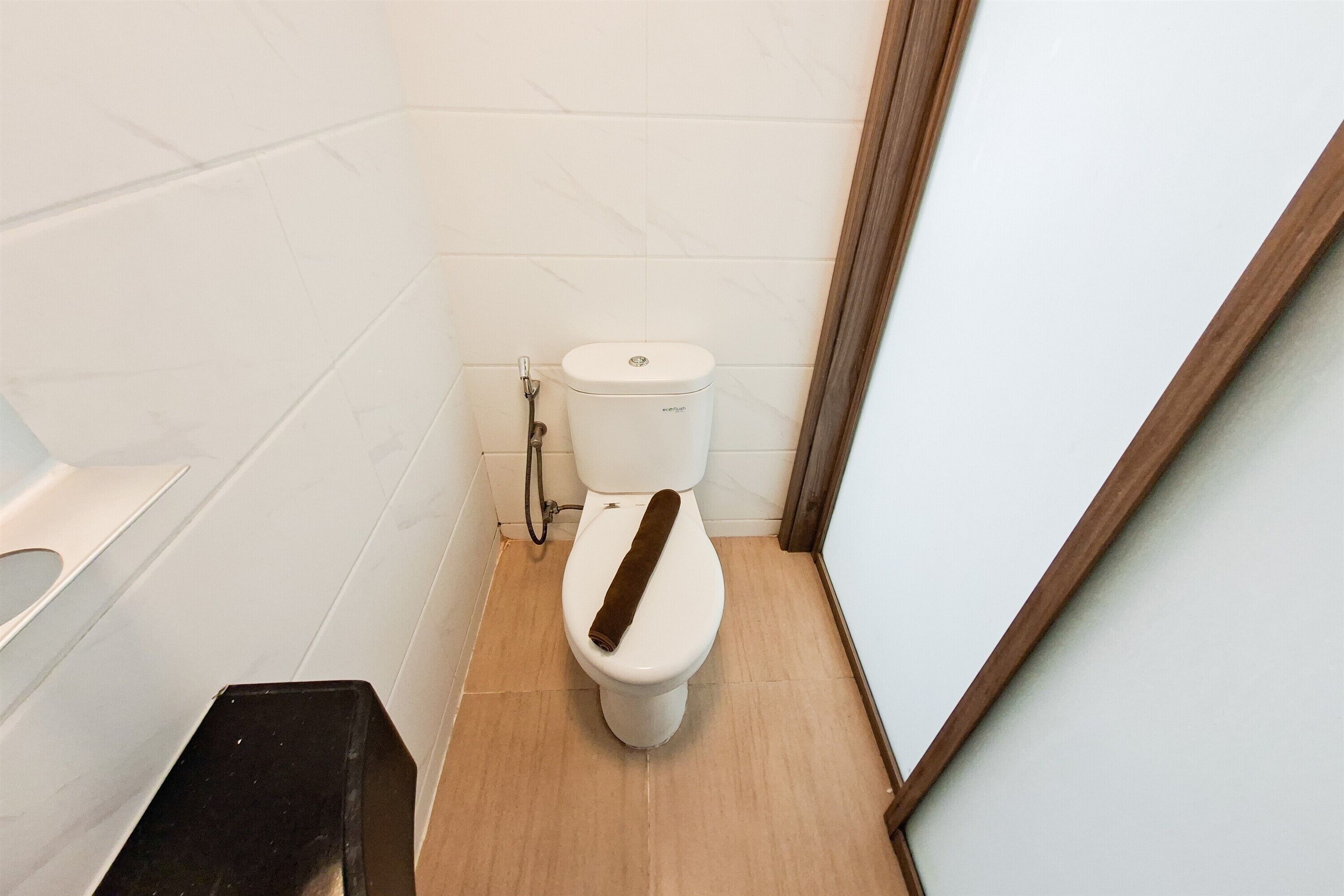 A small, compact bathroom with a toilet, a shower, and a sink.