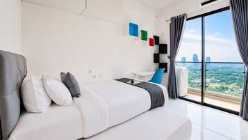 Quarto de hotel moderno com uma cama grande, uma escrivaninha e vista para a cidade.