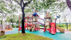 A playground with slides, climbing structures, and a bridge. - Compact And Warm 2Br Apartment Sky House Bsd (Tangerang)