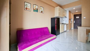 A modern kitchen with a black refrigerator, a stove, and a microwave. - Compact And Warm 2Br Apartment Sky House Bsd (Tangerang)