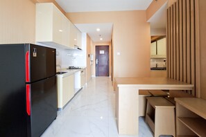 Eine moderne Küche mit einem schwarzen Kühlschrank, einem Holztisch und einer Kücheninsel.