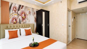 A hotel room with a bed, a wall mural, a wardrobe, and a door. - Sophisticated Studio At Apartment Springlake Summarecon Bekasi (Bekasi)