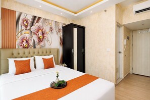 Ein Hotelzimmer mit Bett, Wandgemälde, Kleiderschrank und Tür.
