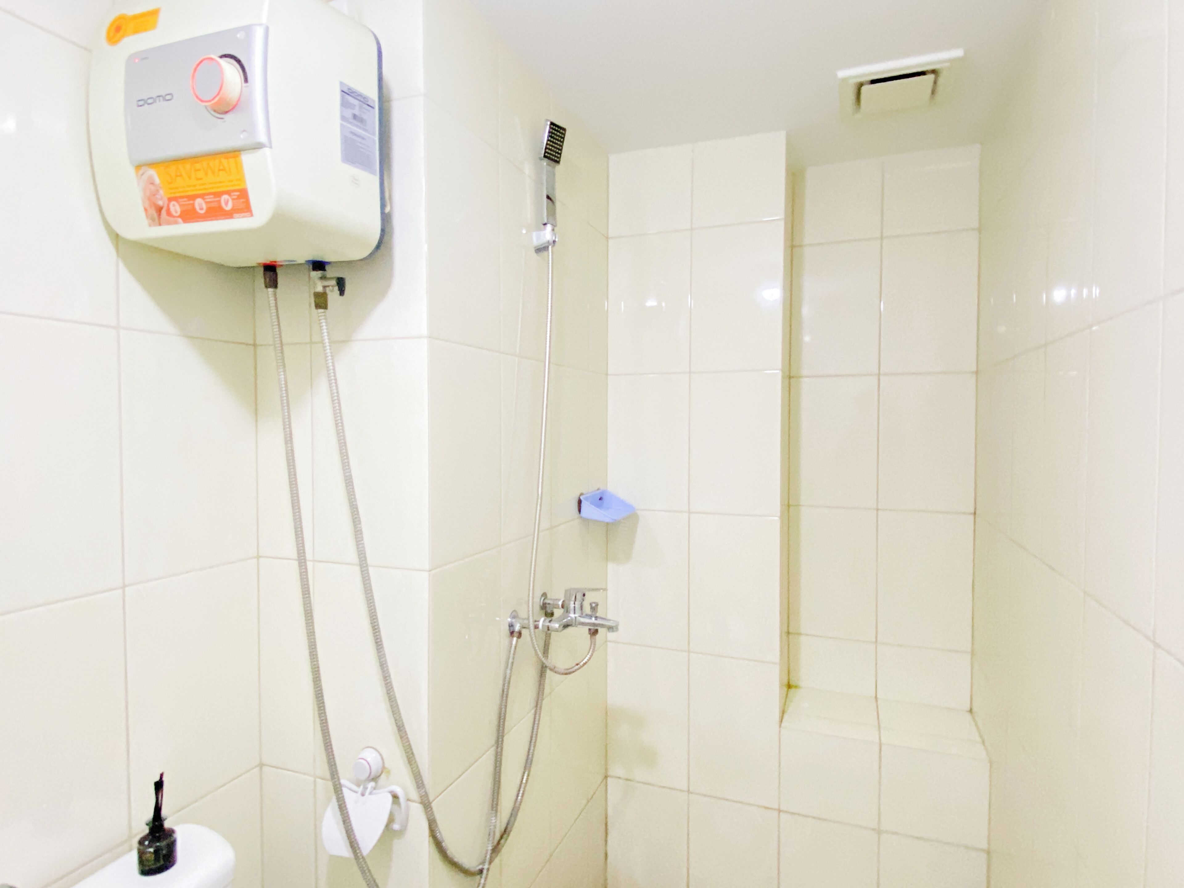 A bathroom with a shower, a toilet, and a water heater.